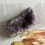 Amethyst crystal with other crystals on a book