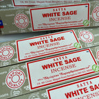 Multiple boxes of Satya White Sage Incense with red and white labels.