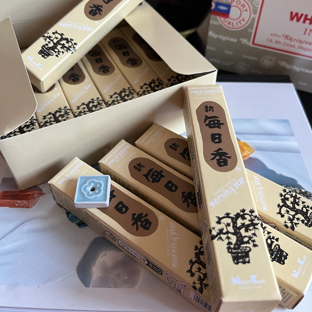 Stack of incense boxes with visible branding on a white surface