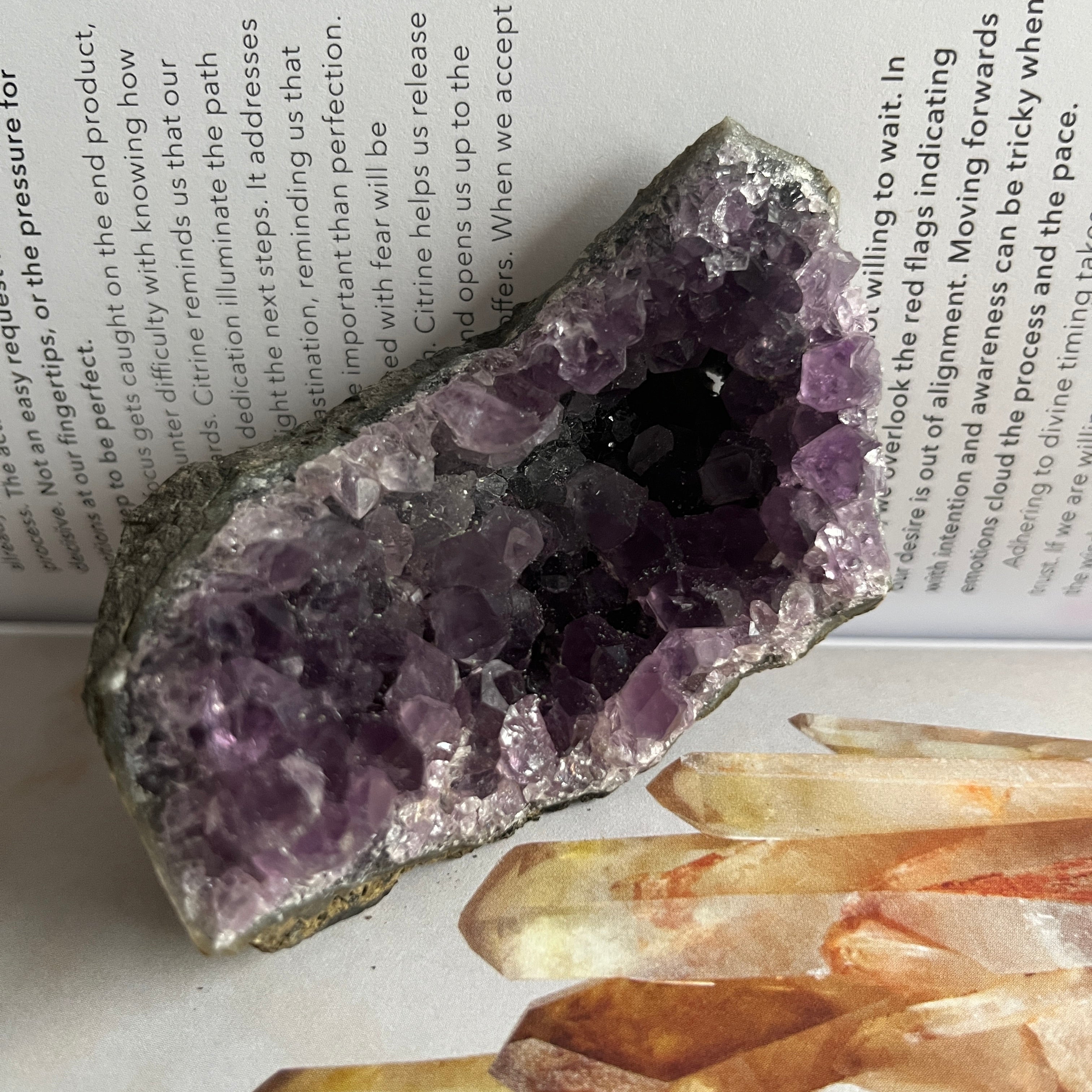 Amethyst crystal formation on a book with other crystals below