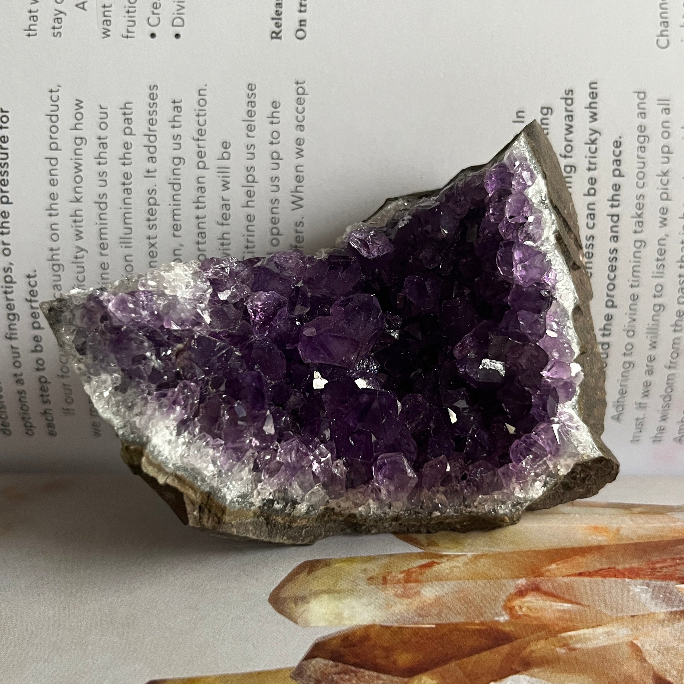 Amethyst crystal on a book with other crystals below