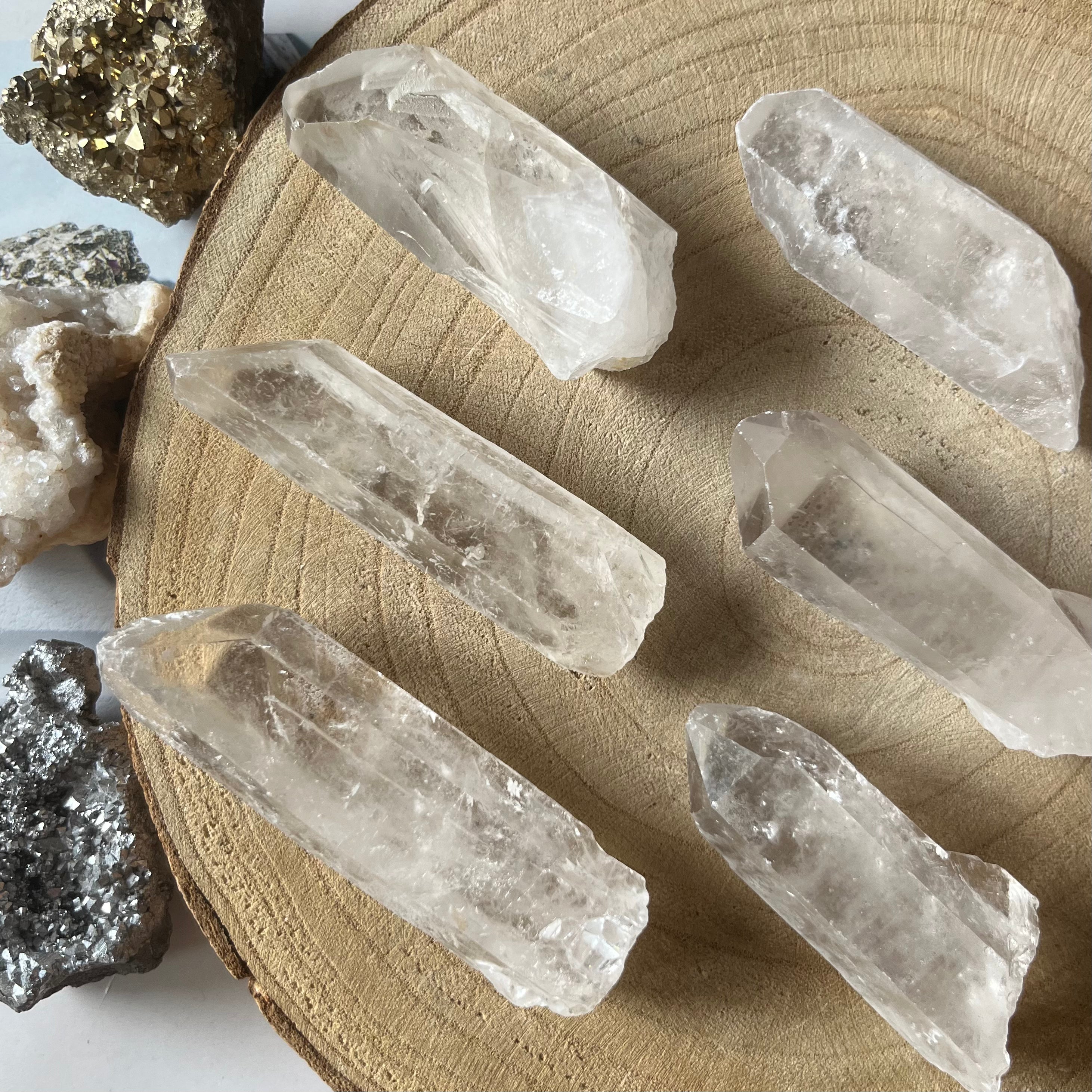 Clear crystal points on a wooden surface with a white background