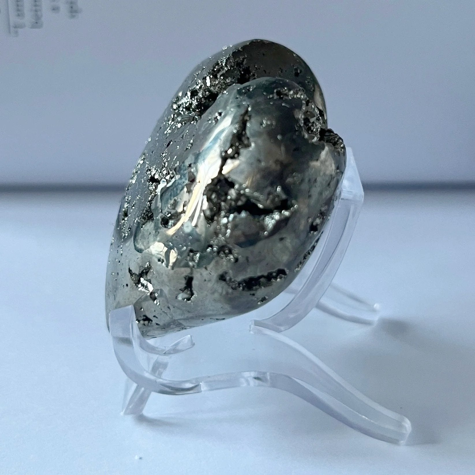 Pyramid heart held in a hand with a printed document in the background