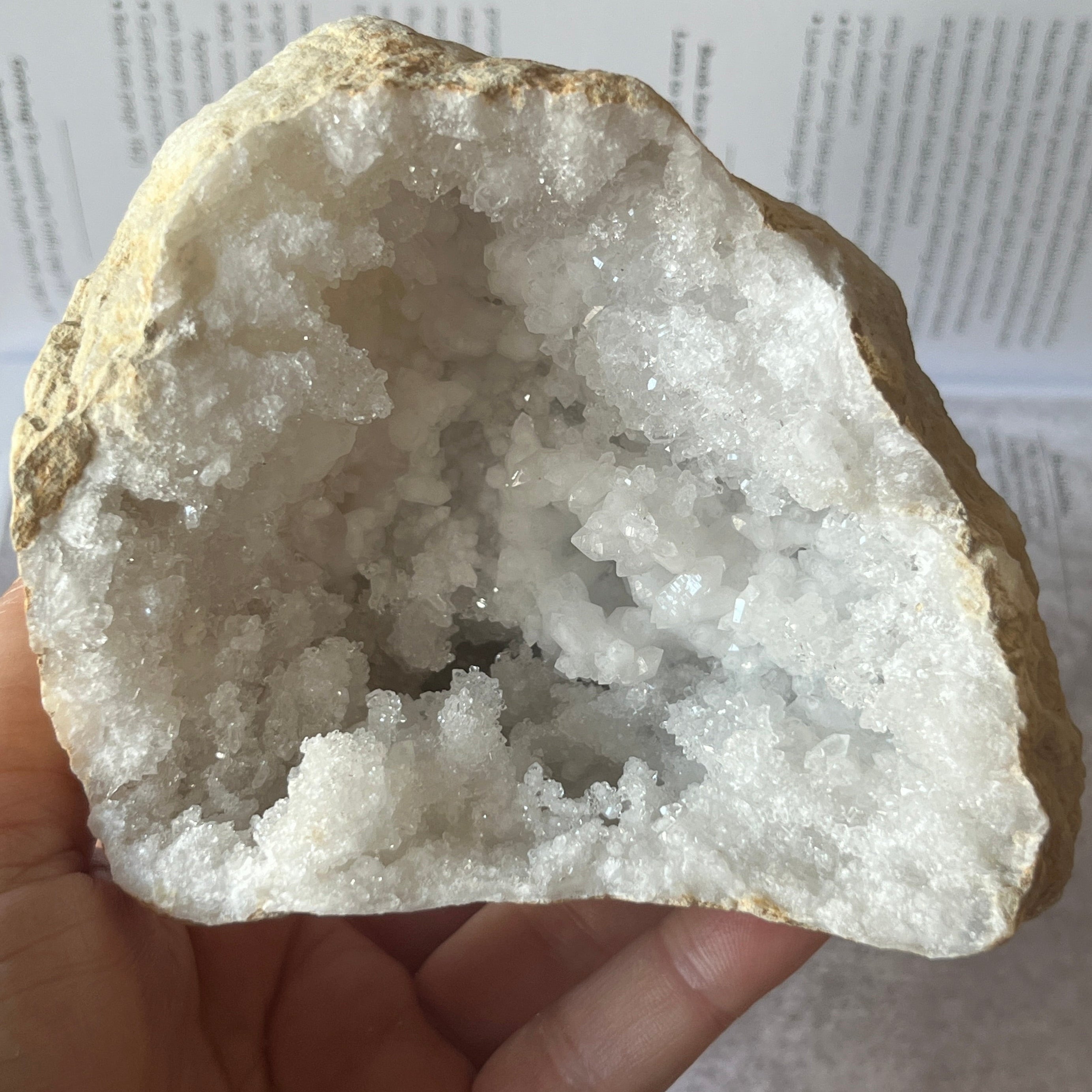Crystal geode held in a hand with a blurred background