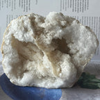 Geode crystal on a blue stand with a white background